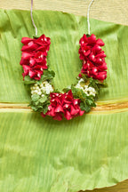 Pyaari-Dulari-Mahua Floral Studio-A wreath of red and green flowers with white accents, designed to be worn at a wedding.