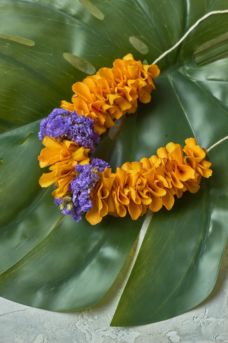 golden-gajra-Floral leaf with yellow and purple flowers on a large green leaf
