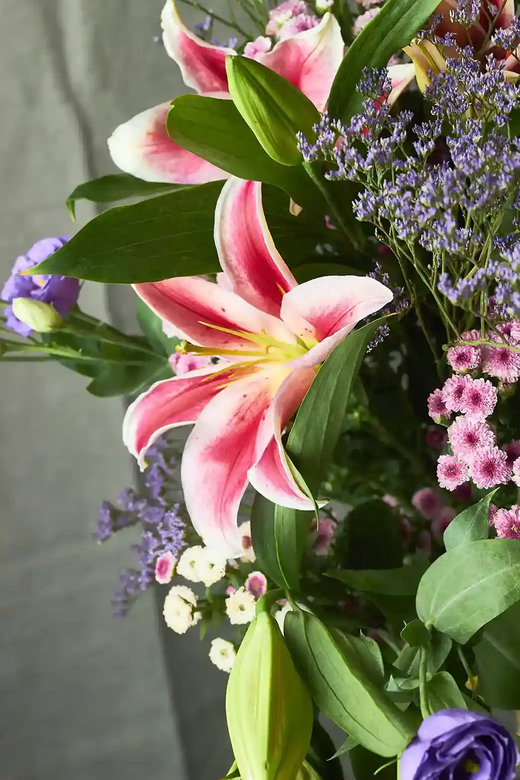 Bouquet of pink lilies and other flowers with a blurred background