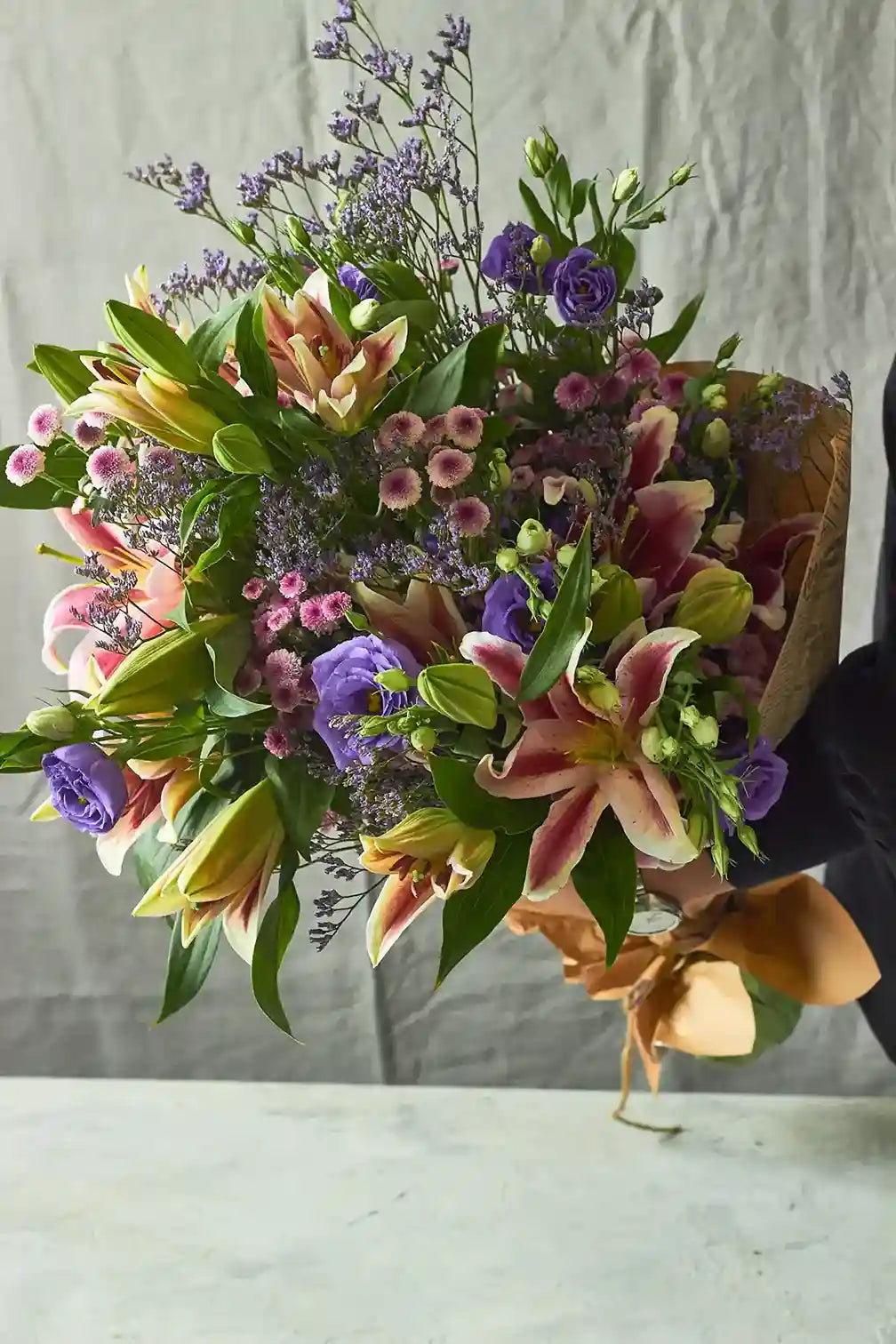 Bouquet of flowers with pink, purple, and green colors on a neutral background